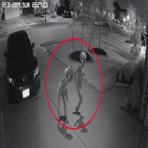 Shocking video shows two aliens appearing in a residential area in the US and breaking into houses to capture humans, causing confusion.